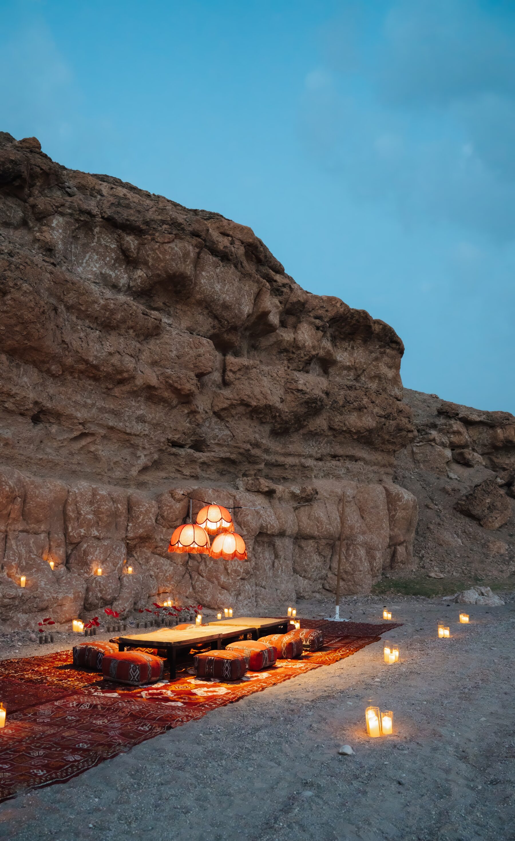 Sunset dinner setup in the Agafay desert near Marrakech with lanterns